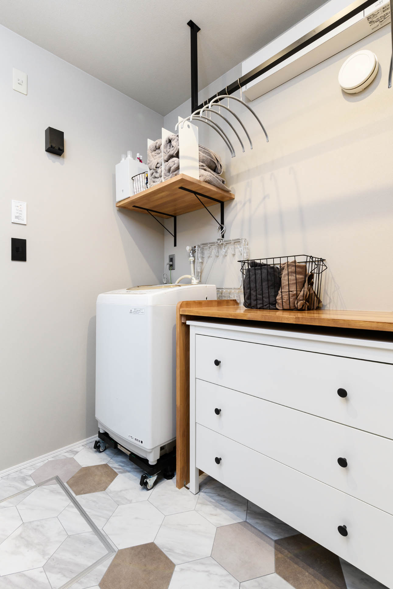 日本語: 室内干しを想定し既製品に合わせて造作家具を計画した脱衣室 / English: Laundry room with custom furniture designed for indoor drying needs