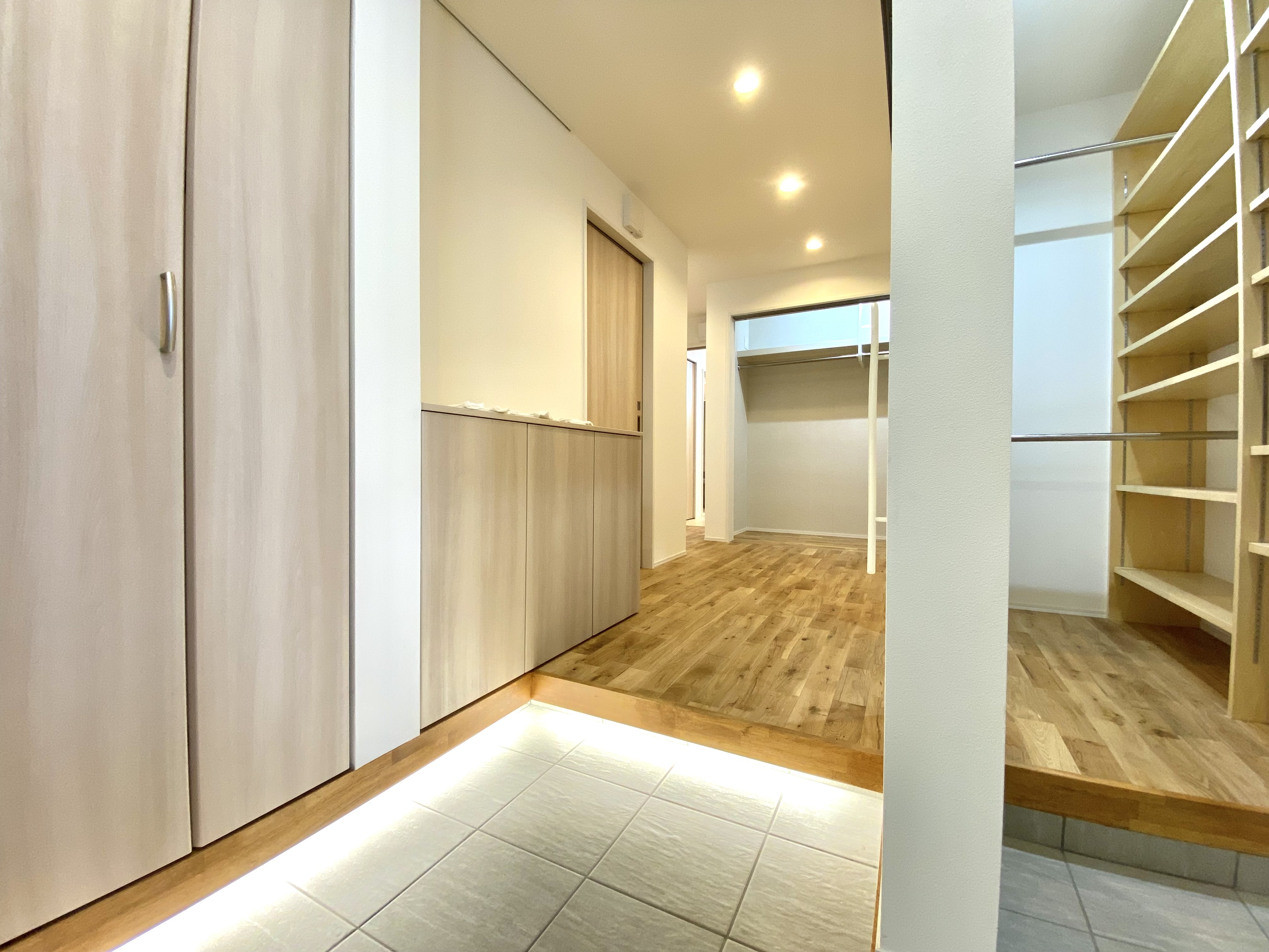 日本語: 足元灯の間接照明が美しい玄関と玄関収納 ｜ English: Entrance and storage area with elegant indirect lighting from floor-level lamps